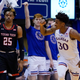KU’s Ochai Agbaji celebrates as Texas Tech’s Adonis Arms looks on in yesterday’s double-OT thriller.